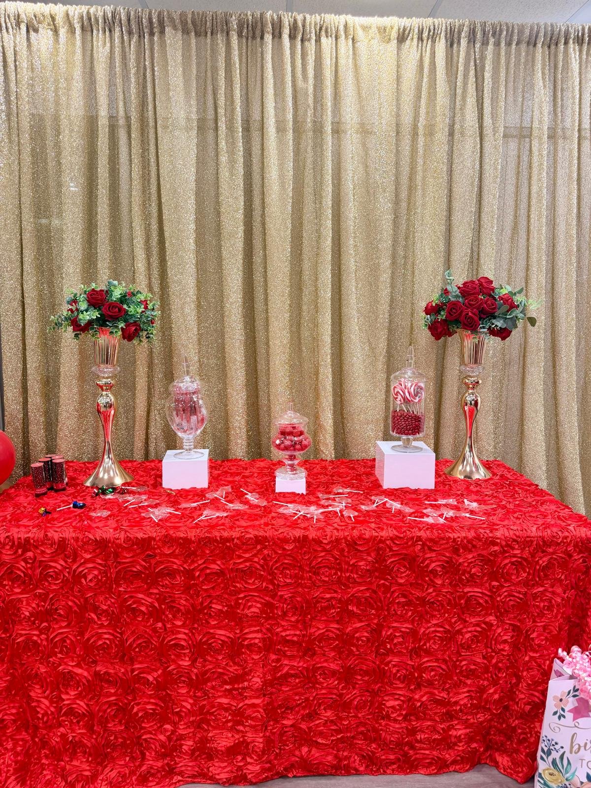 Red candy table with gold curtain backdrop